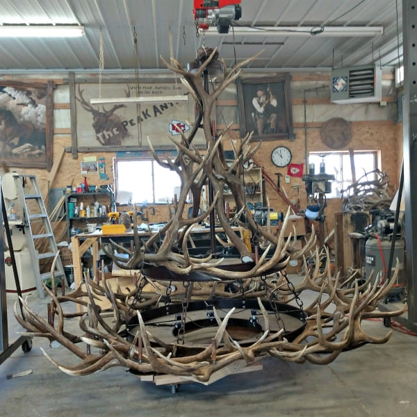 Two tiers of large custom antler chandelier being assembled