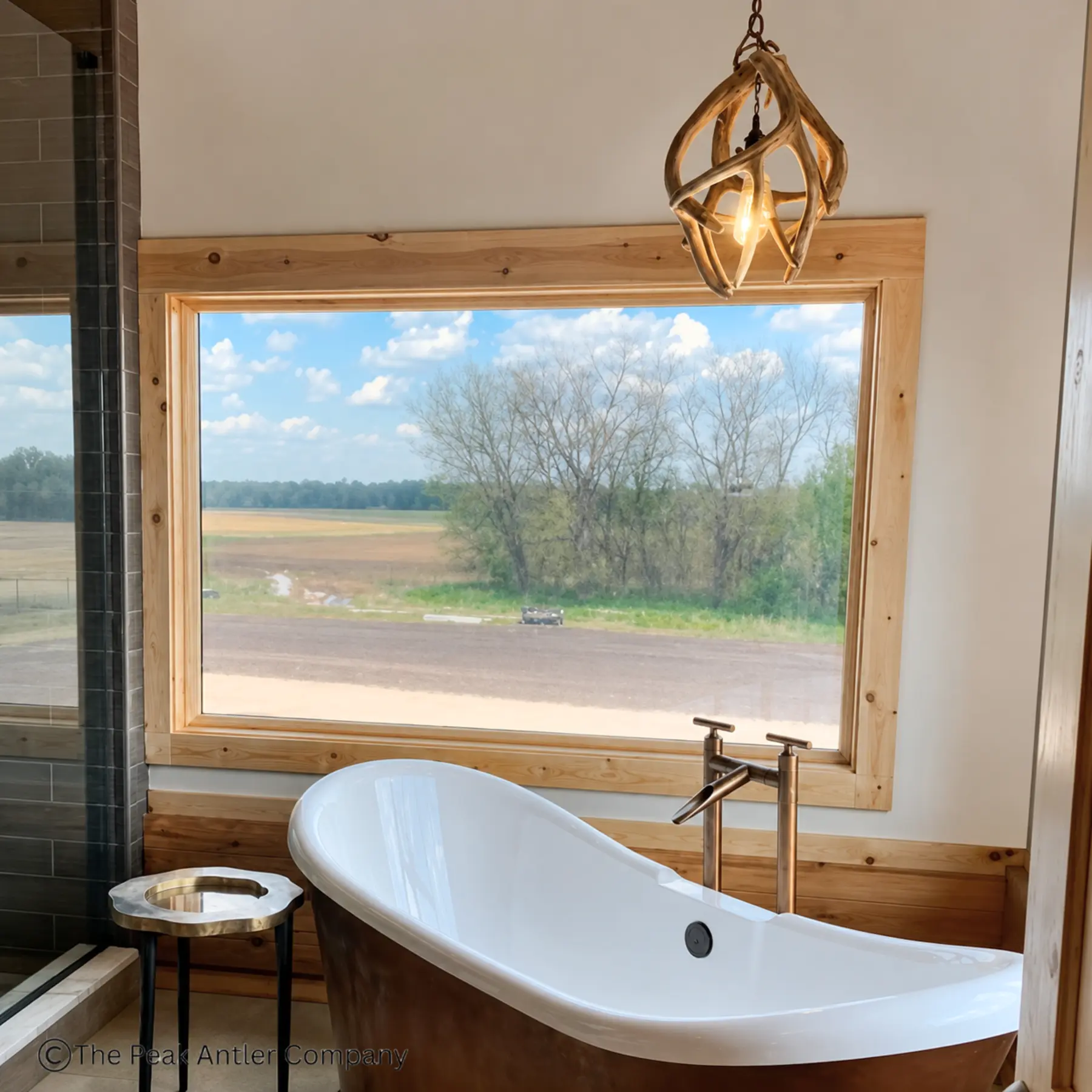 Mule Deer antler globe pendant light in a home master bathroom over the bathtub
