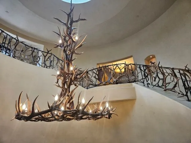 A XL Mt. Elbert chandelier hanging in a grand spiral staircase in a Colorado home