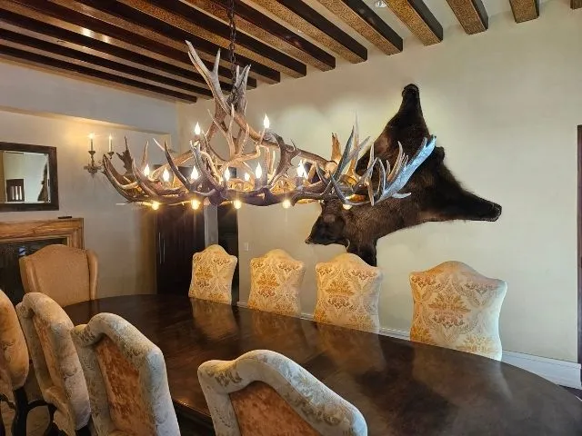 A Longs Peak antler chandelier hanging over a dining room table in Colorado