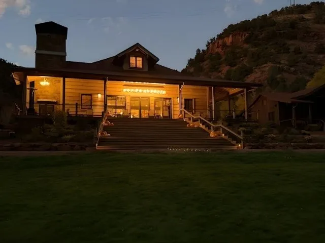 A wide view of a luxury home with a Snowmass Chandelier on the porch