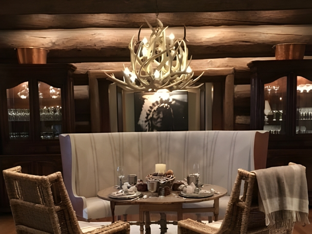 A Sunshine Peak Antler Chandelier, hanging above a rustic kitchen table at Seven Lakes Ranch, CO