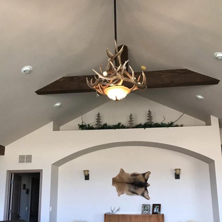 Custom small antler chandelier hanging in a high ceiling room