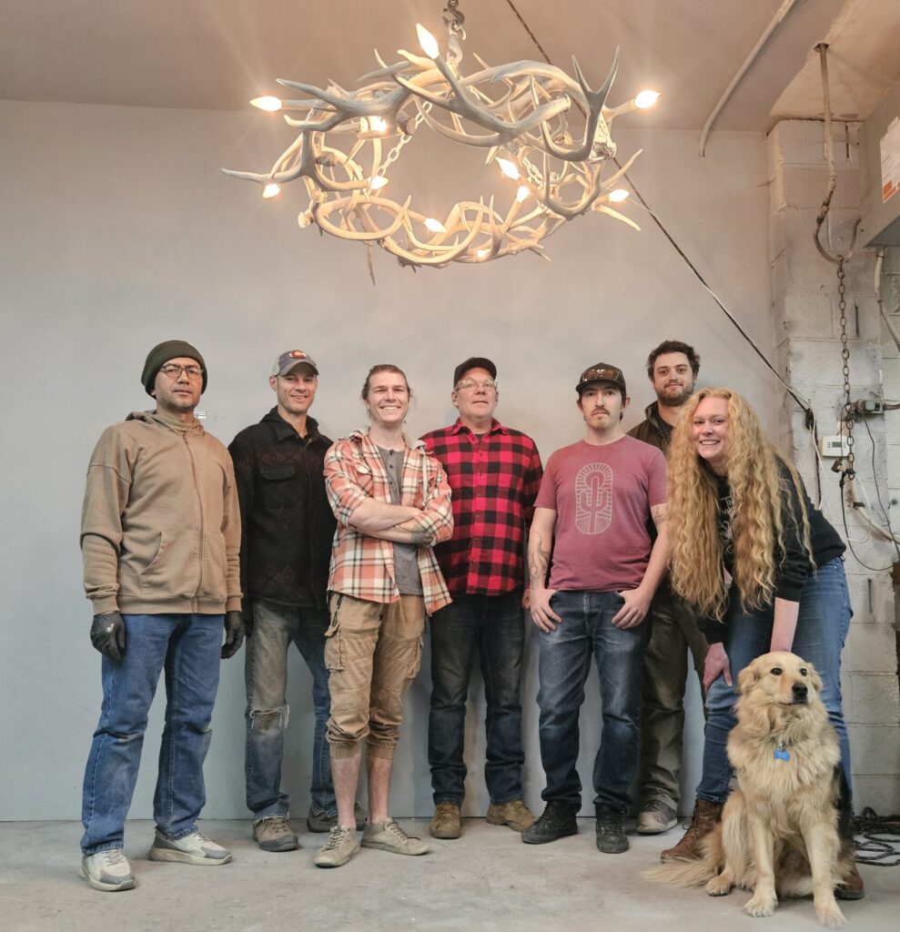 Peak Antler Team posing with circular Halo antler chandelier