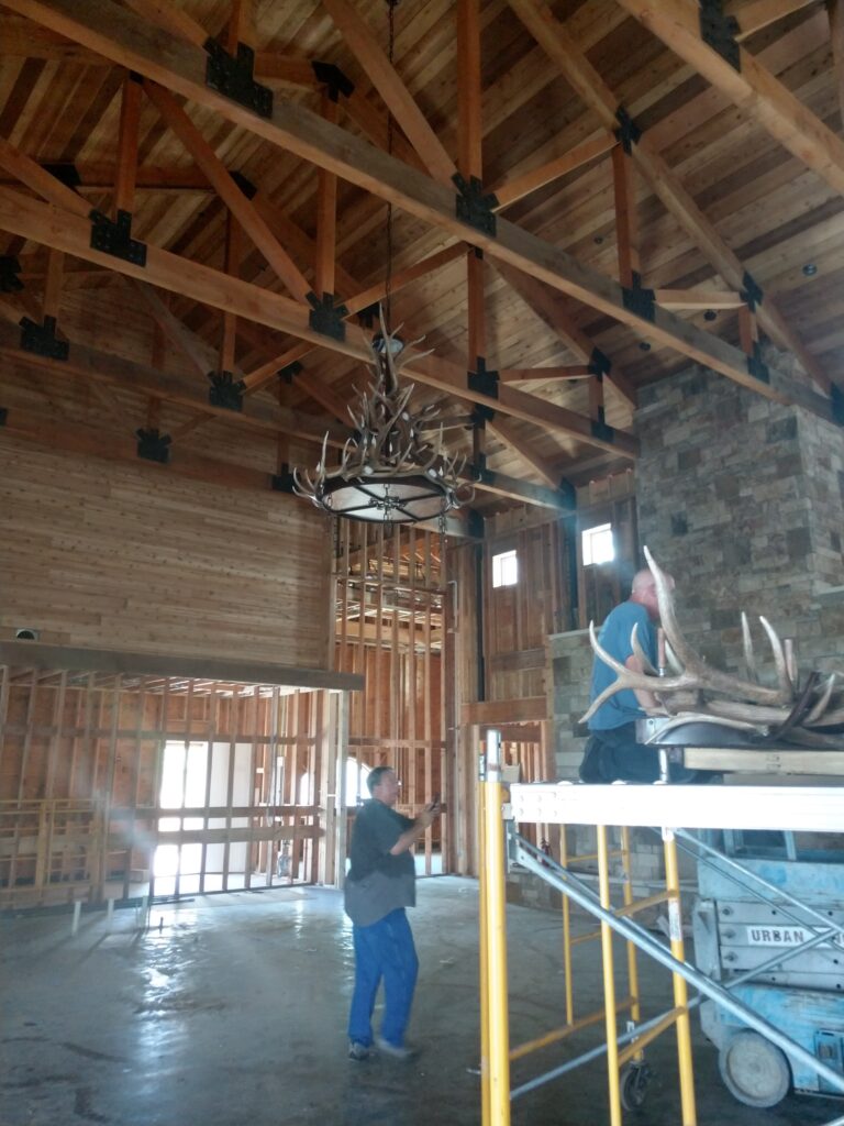 Large custom antler chandelier of two tiers being installed in home
