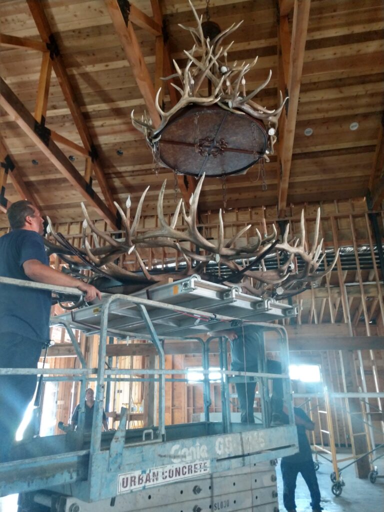 Large custom antler chandelier of two tiers being installed in home